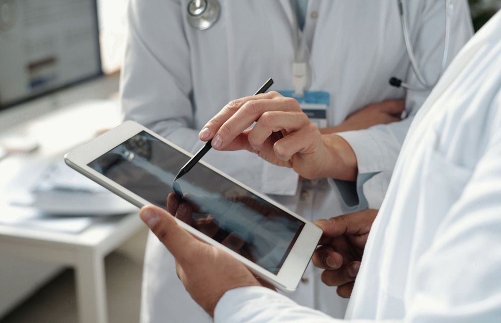 Medical professionals using a tablet to analyze imaging data