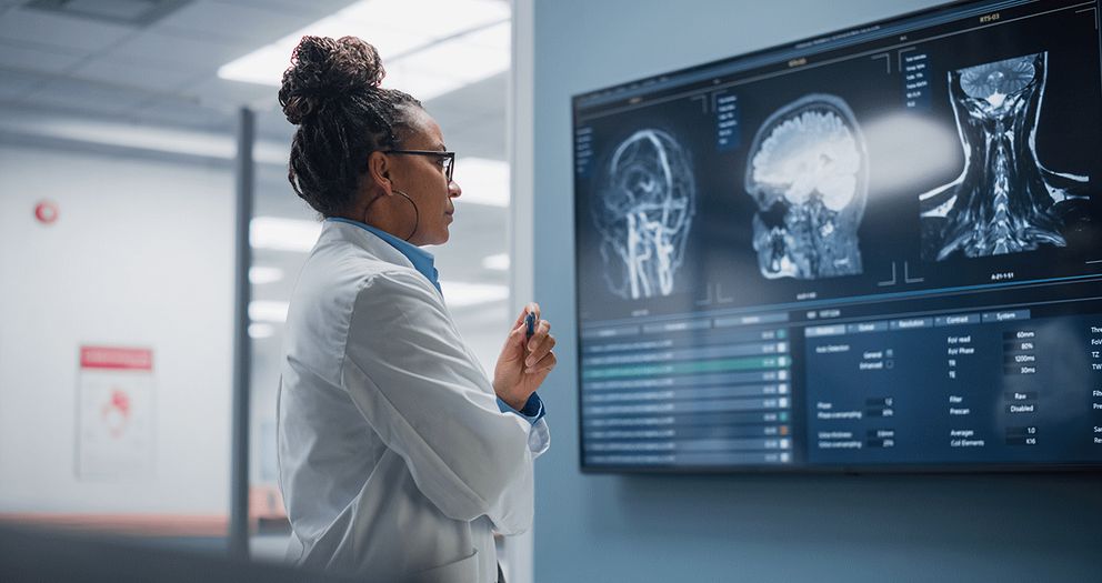Medical professional examining scanner images on a large dashboard display